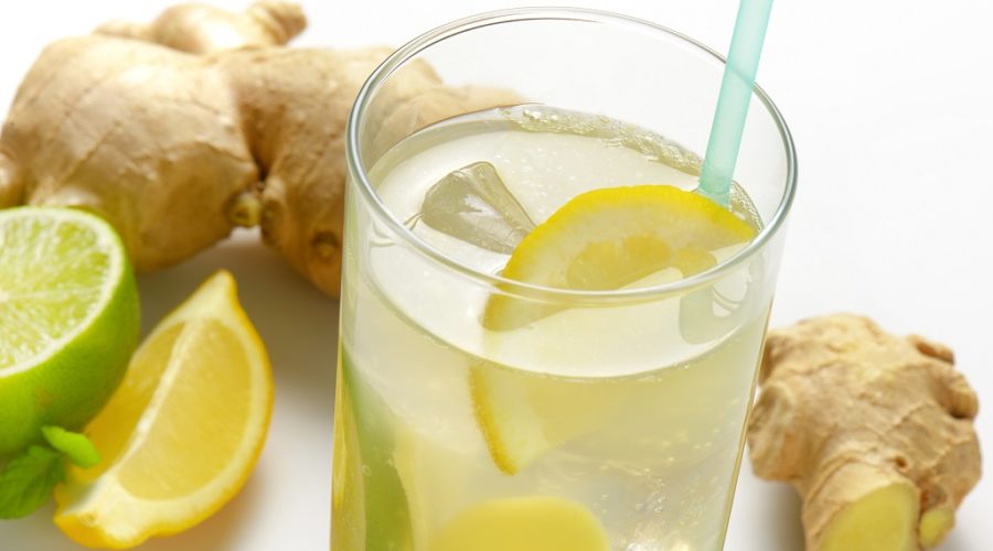 detail of glass of ginger ice tea with lemon and fresh ginger