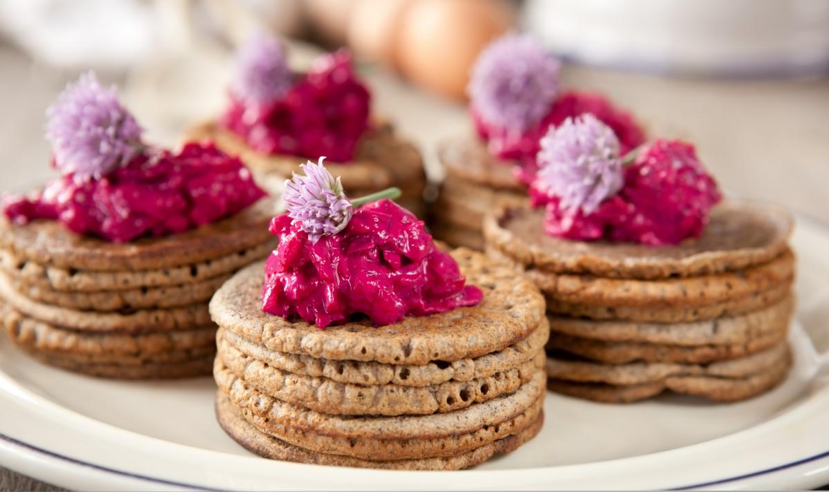  Mini buckwheat pancakes garnished with beetroot salad and chives blossoms